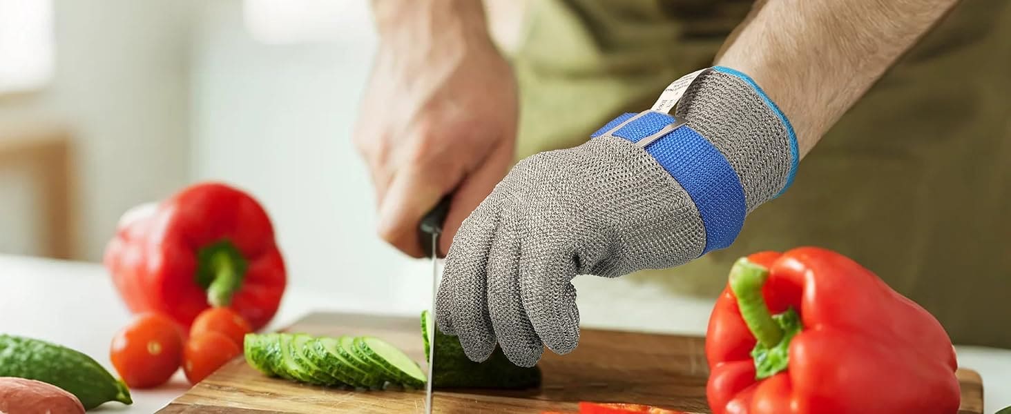 Person wearing a glove while cutting vegetables on a wooden board