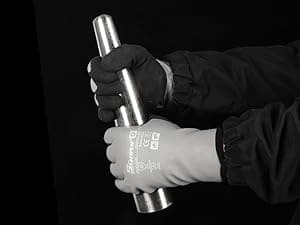 Hand holding a metallic object with a brand logo against a black background