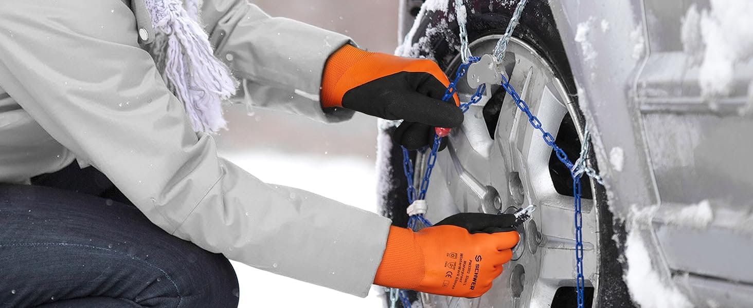 Person securing snow chains on a car tire with gloves on