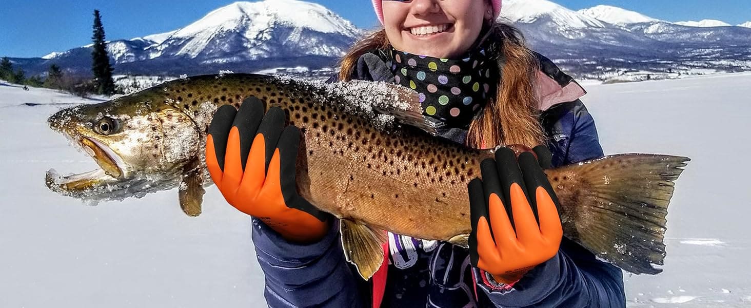 Person holding a large fish in a snowy landscape with mountains in the background