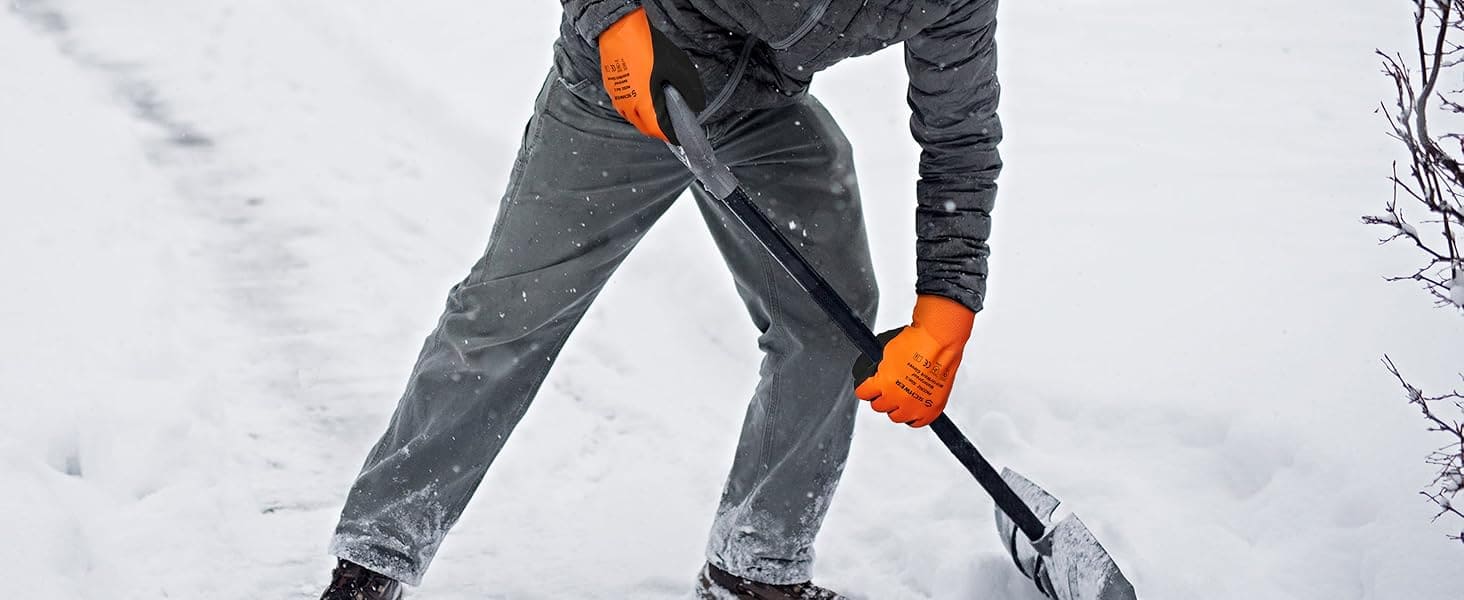 Person shoveling snow wearing gray pants and orange gloves