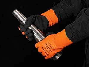 Person wearing orange gloves holding a metal rod against a black background