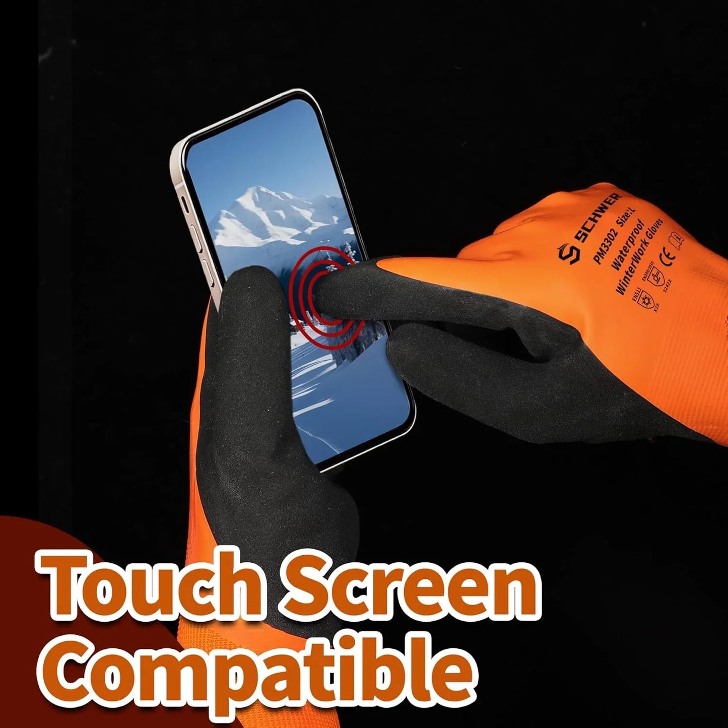 Orange and black waterproof winter work gloves using touchscreen smartphone with snowy mountain on screen