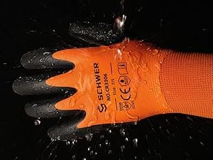 Orange work glove with black gloves on a dark background