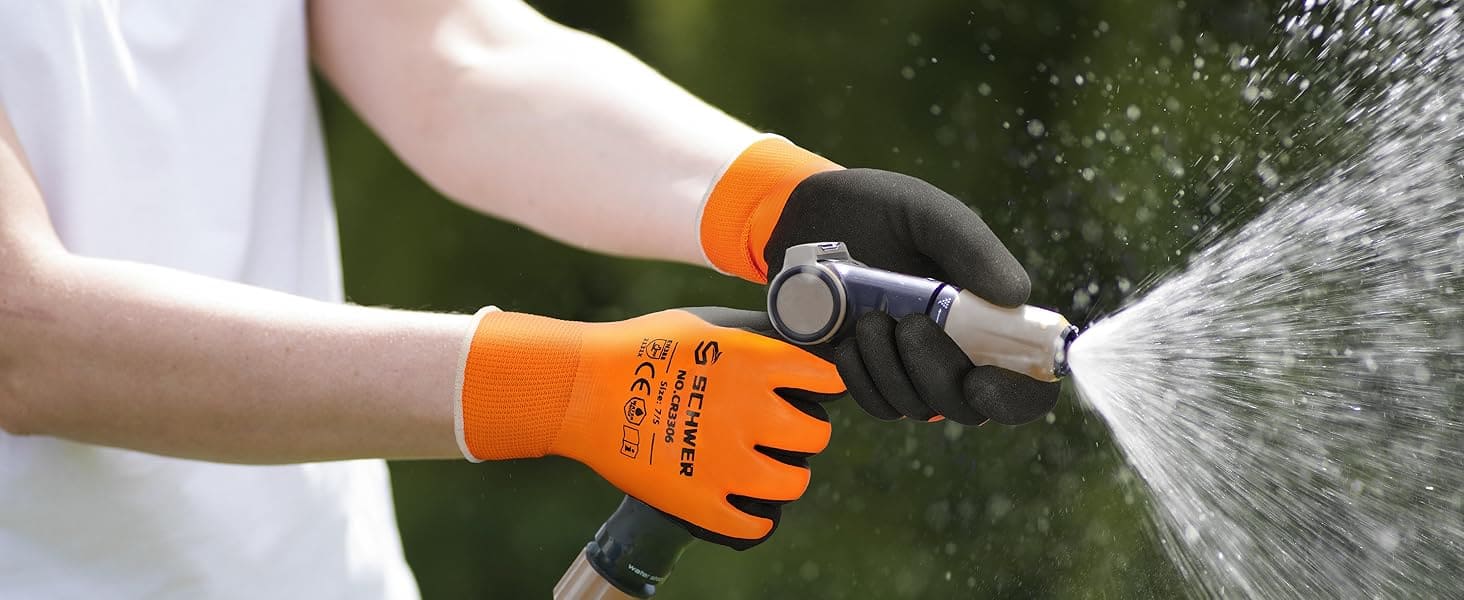 Person wearing orange and black gardening gloves using a hose to spray water.