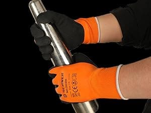 Person wearing orange gloves holding a metal rod against a black background