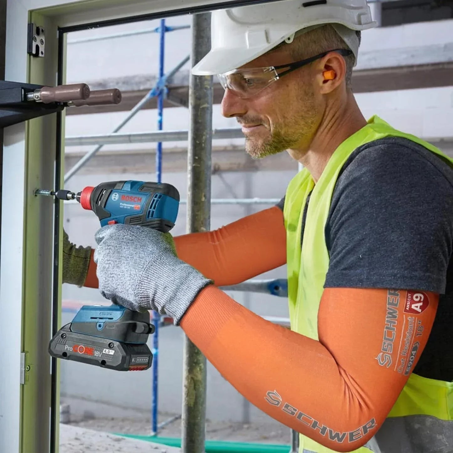 Worker using a power drill on a construction site