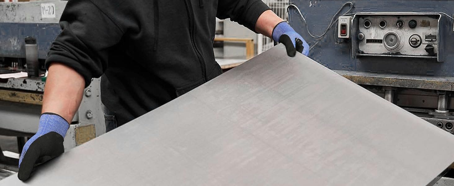 Person handling a large sheet of material in an industrial setting